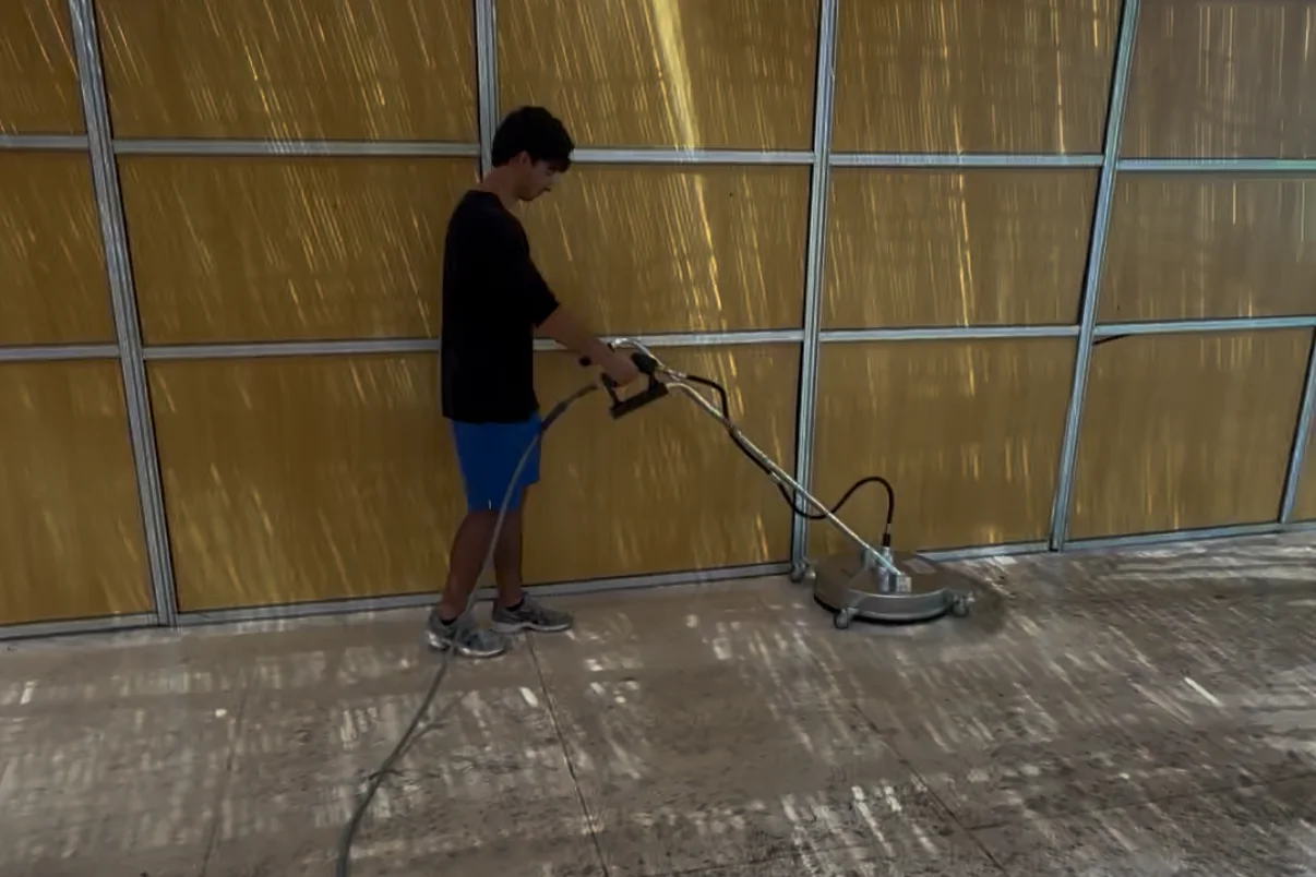 Operator running a 20-inch surface cleaner over a concrete slab
